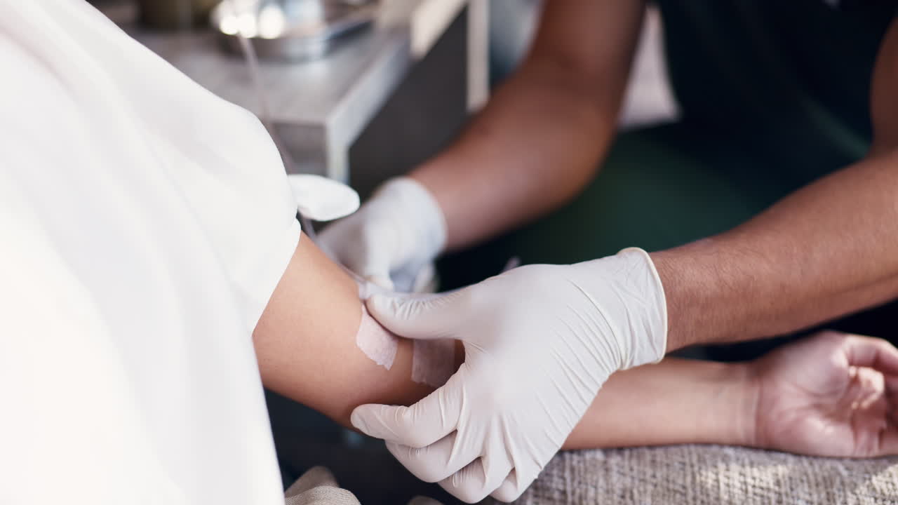 Medical Professional Applying Bandage to Patient's Arm After Procedure