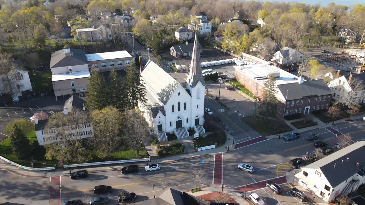 Static drone video of downtown Hingham's North Street, revealing church, post office, commerce and other activity. Aerial. MA USA