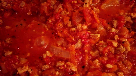 closeup of a boiling traditional bolognese sauce