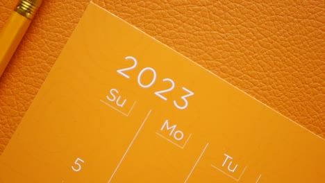 orange 2023 calendar with pencil