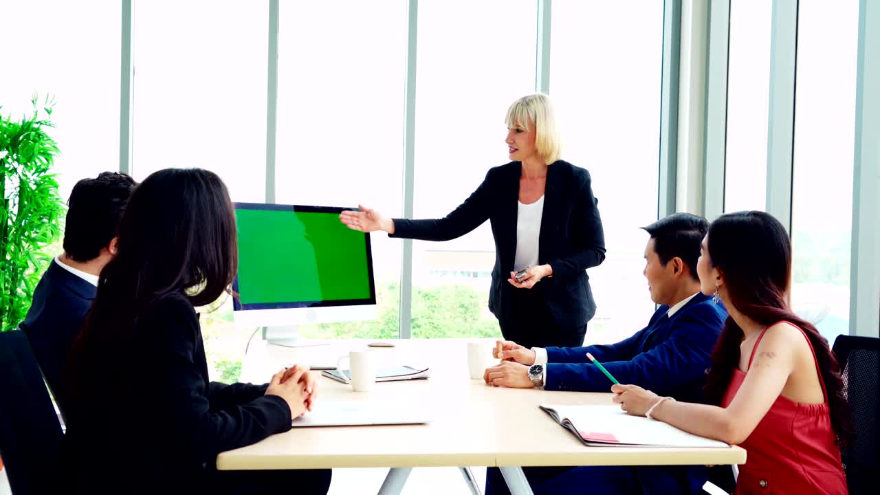 녹색 스크린을 가진 회의실에 있는 비즈니스 사람들