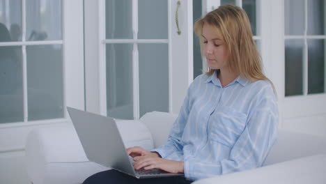 Young-business-woman-worker-relax-sit-at-office-desk-finished-laptop-computer-work-put-hands-behind-head-feel-satisfied-with-work-well-done-stress-relief-peace-of-mind-concept-chill-at-work