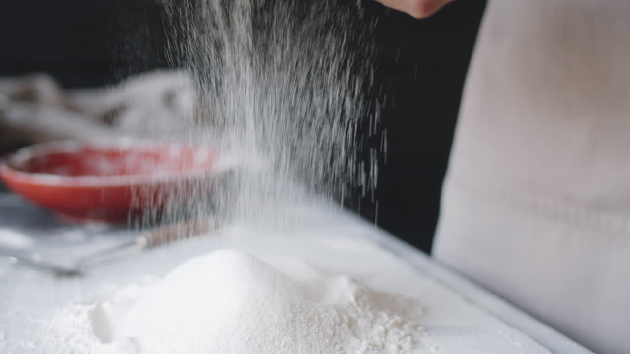 Close Up of Hands of Female Baker Sifting Flour