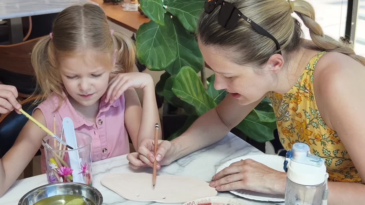 madre e hija aprendiendo cerámica