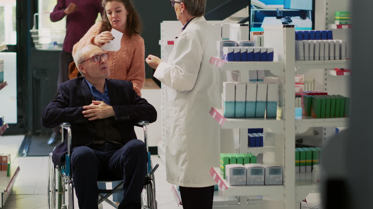 Senior man in wheelchair at pharmacy with pharmacist and caregiver