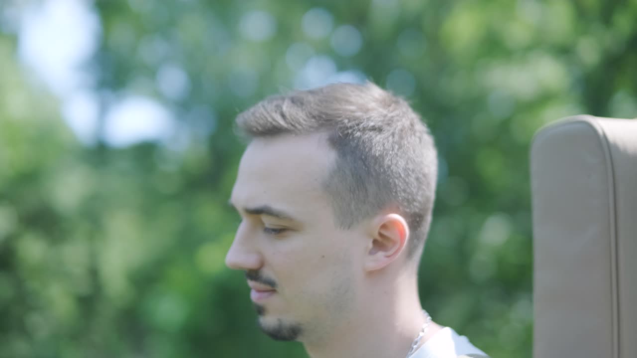 숲 근처의 거리에서 기타를 들고 는 젊은 남자