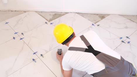 a worker laying large wideformat floor tiles