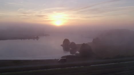 Drone-view-of-small-lake-at-Fortress-Bourtange-during-foggy-morning,-aerial