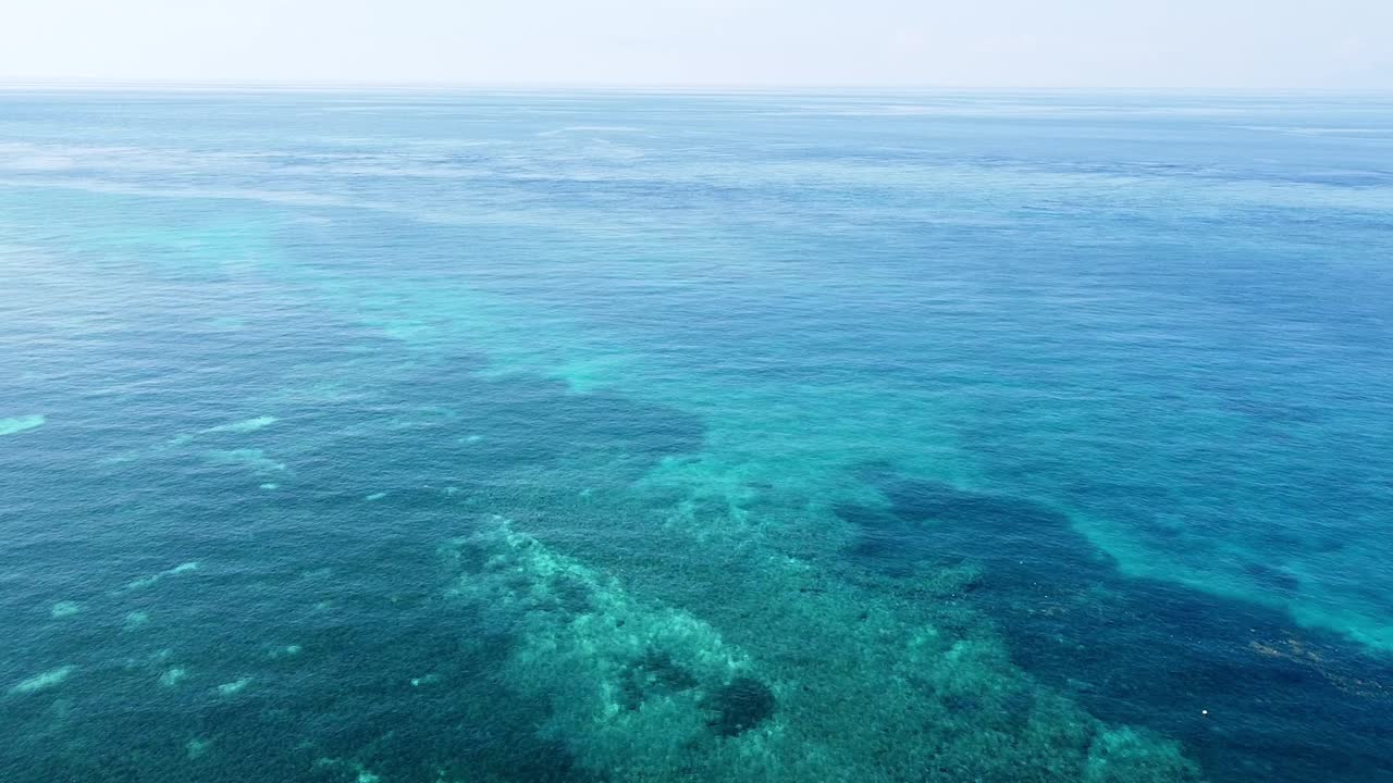 vuelo aéreo inverso de drones sobre un impresionante arrecife triangular de coral y aguas cristalinas del océano turquesa en un remoto destino de isla tropical, sudeste de asia