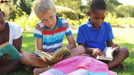 grupo de niños leyendo libros en el parque