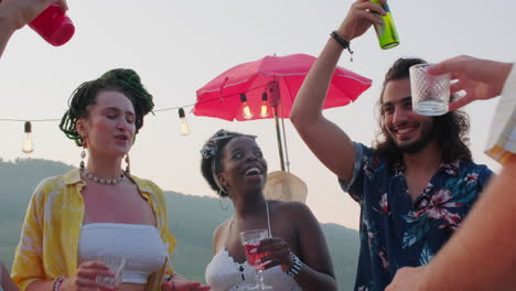 joyous friends dancing and toasting at outdoor summer party