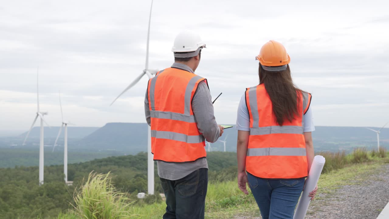 Progressive concept of engineers working in the wind farm atop of the mountain.