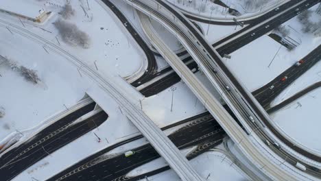 Vista-Aérea-De-Una-Intersección-De-Autopistas-Cubierta-De-Nieve-En-Invierno.