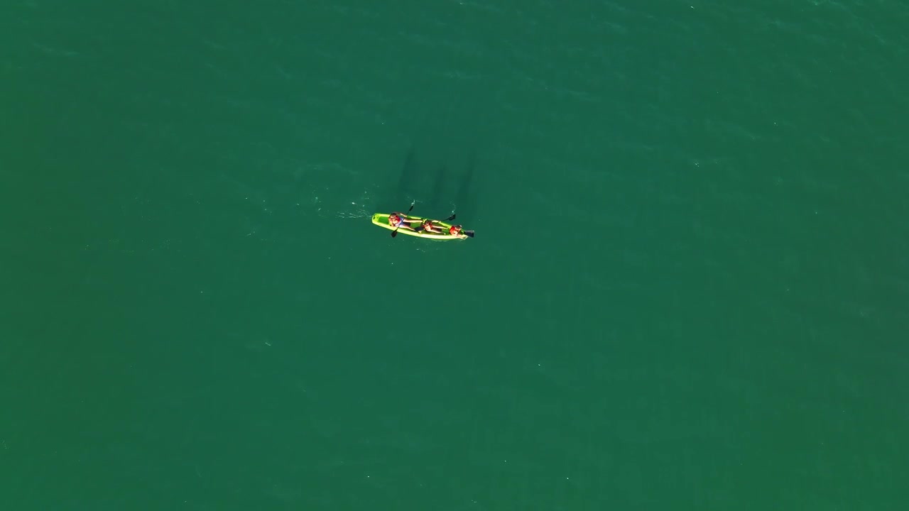 Top-down shot of a family kayaking in the tropical waters of Mendoza, Argentina