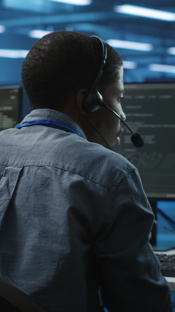 African American Man Coding and Wearing Headset in Tech Office