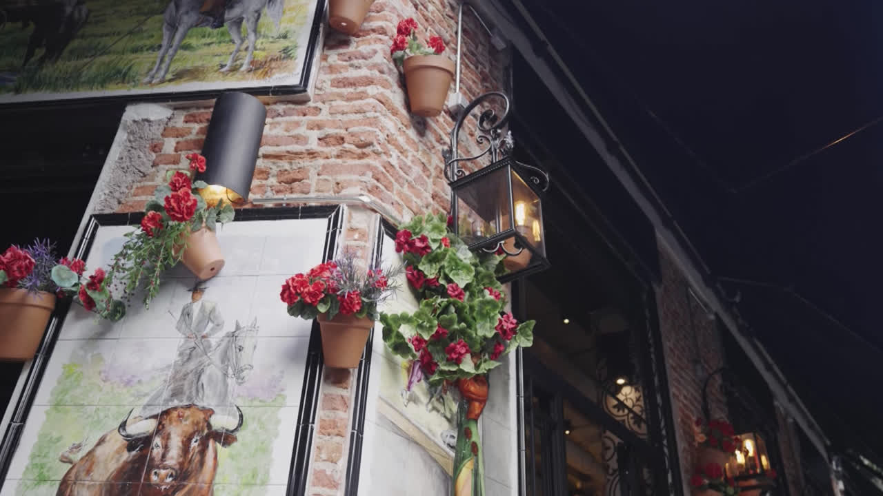 Beautiful slow motion zoom in shot of a potted flower decoration hanging on the facade of a restaurant in front of the Las Ventas bullring in Madrid, Spain.
