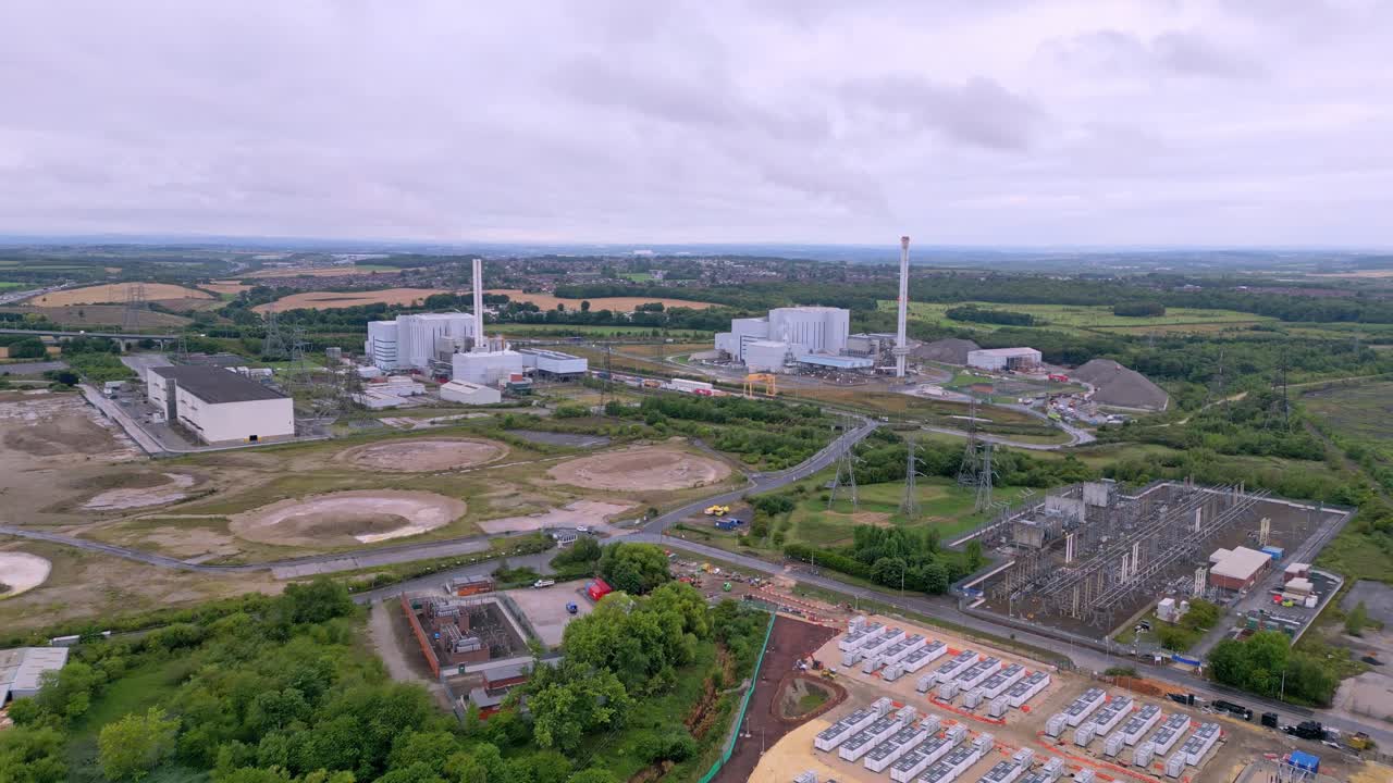 Aerial drone footage over a battery energy storage system and electrical substation in rural England, showing modern renewable energy infrastructure, energy transition and sustainability concept