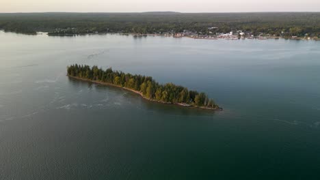 Aerial-fly-to-small-island-at-sunset-golden-hour,-Hessel,-Michigan,-Les-Cheneaux-Islands