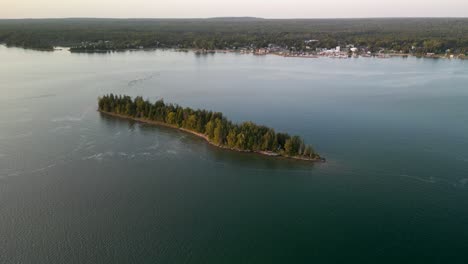 aerial fly to small island at sunset golden hour, hessel, michigan, les cheneaux islands