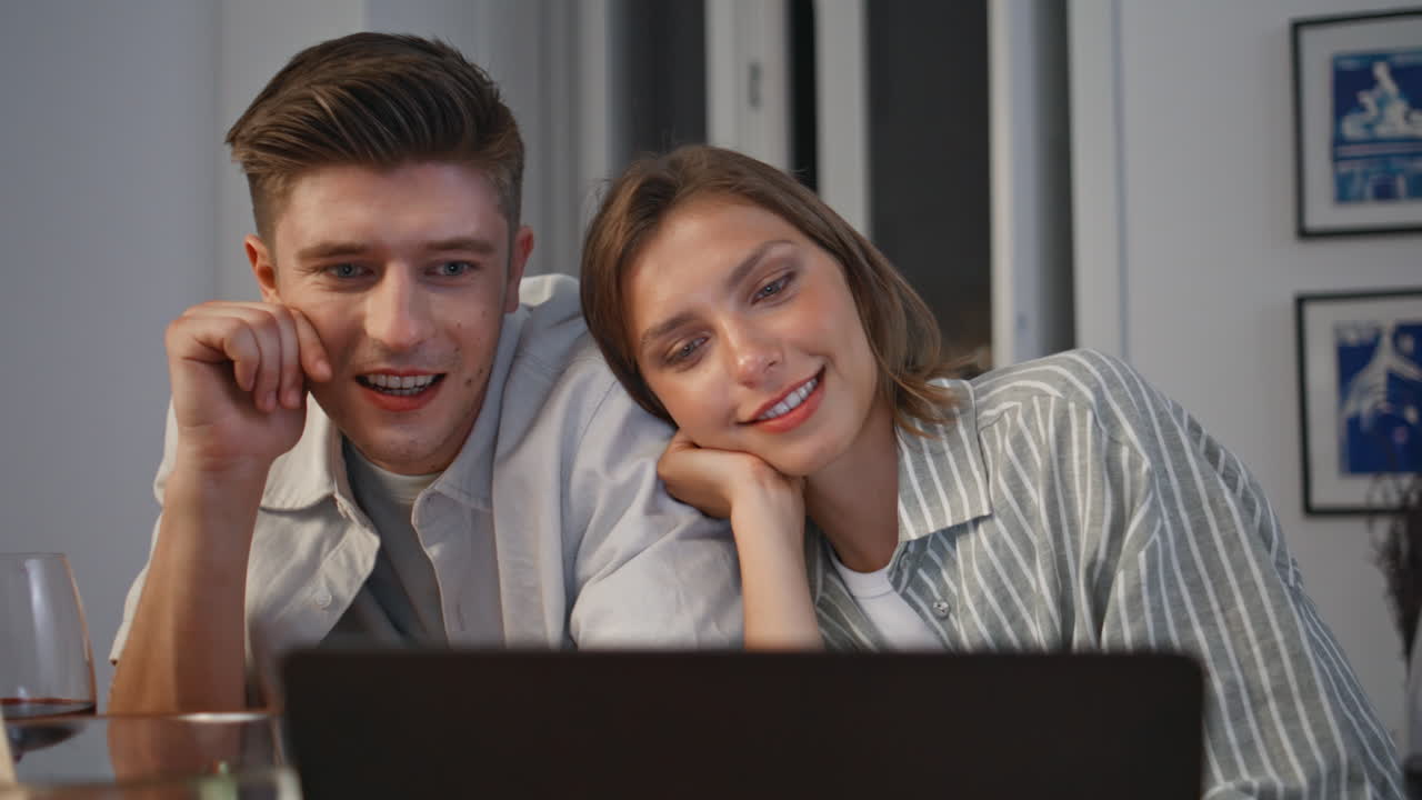 Love pair watching laptop movie at home closeup. Happy couple discussing show