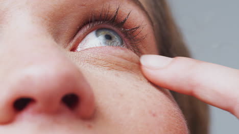 extreme close up as man puts eyedrops into eye shot in slow motion