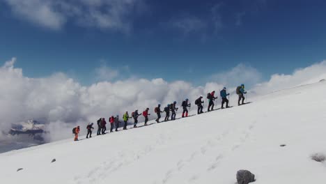 grupo de senderismo en un pico de montaña nevado