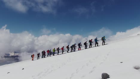 group hiking on a snowy mountain peak