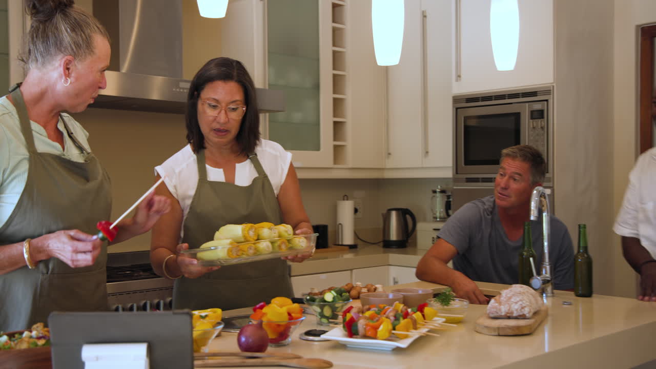 Diverse women in kitchen preparing fresh vegetables, enjoying cooking together at home
