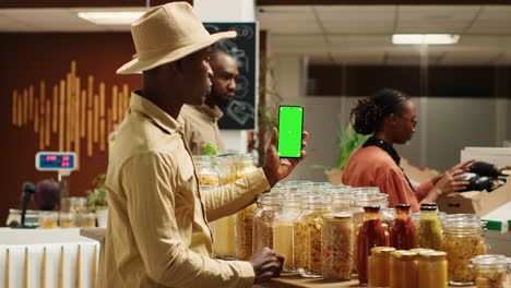 african american seller holding smartphone app with greenscreen