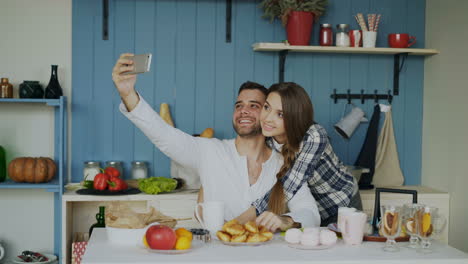 Couple taking a selfie in the kitchen during a meal