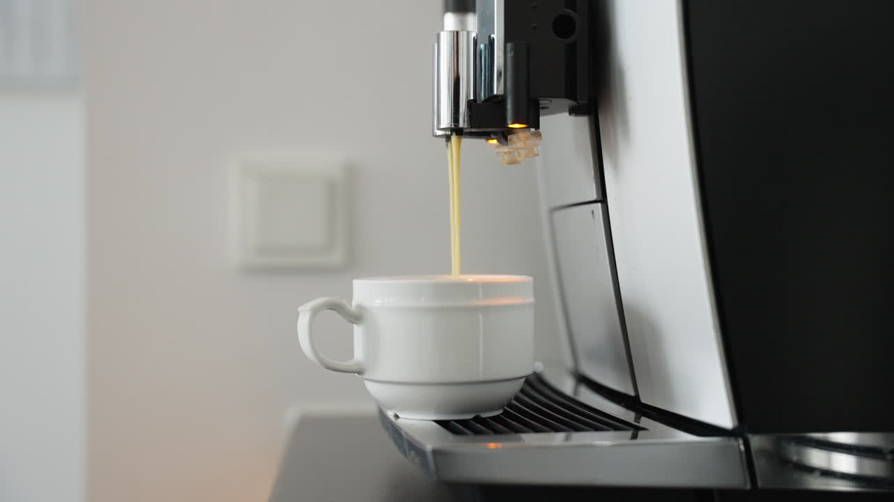 Fresh coffee pouring into a ceramic cup from a modern coffee machine. Perfect for kitchen appliance advertisements or coffee shop promotions