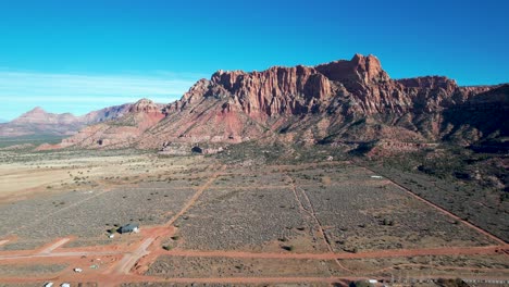 ciudad de colorado, utah, pequeña ciudad con acantilados de roca roja y caminos de tierra - antena