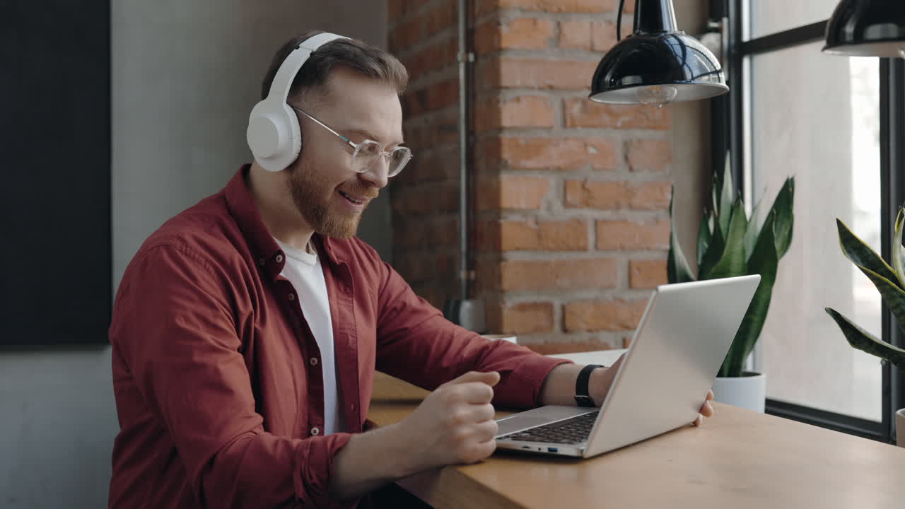 Man working on laptop with headphones on