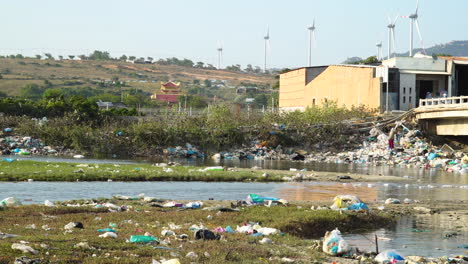 juxtaposition of green energy production  and polluted river