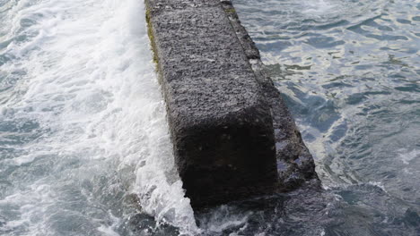 Powerful-crashing-of-tides-on-concrete-pier-creating-calm-scene,close-up