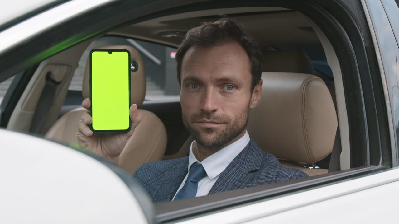 Caucasian Driver Showing Green-screened Smartphone