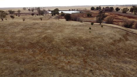 areal drone shot, moving across grassy field on gloomy, overcast day