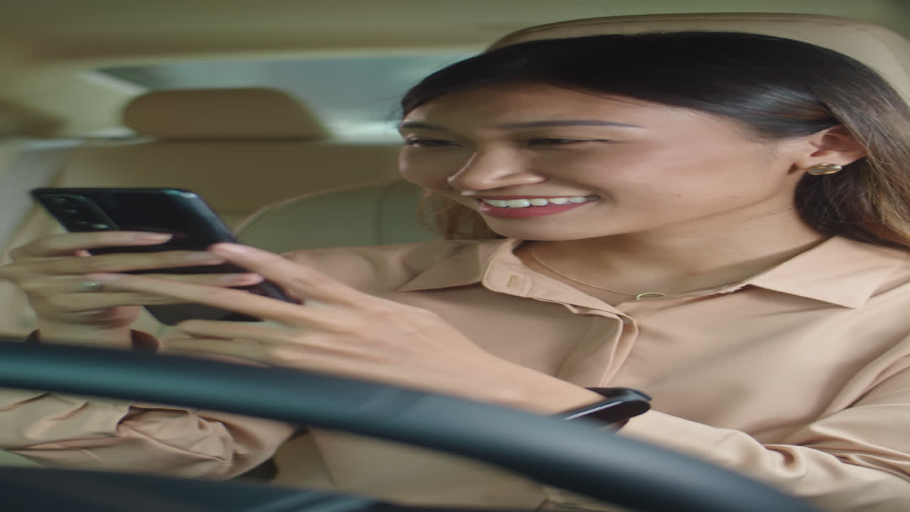 Asian Woman Texting on Phone in Car