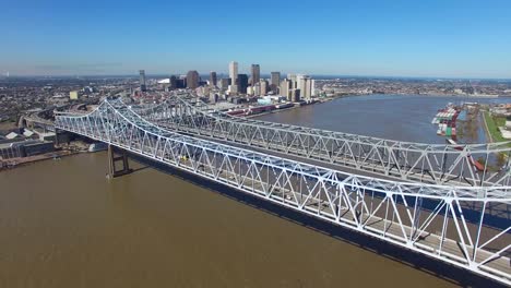 stationary aerial shot of the crescent city bridge over the mississippi river revealing the new orleans louisiana skyline