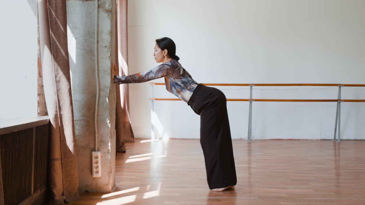 Woman Stretching in a Dance Studio