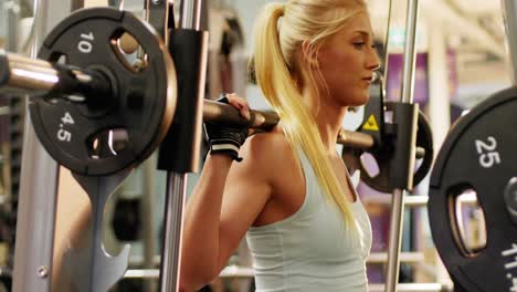 Mujer-En-Forma-Haciendo-Ejercicio-Con-Máquina-Smith