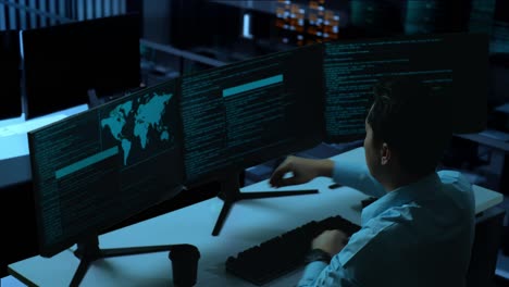 side view of tired asian man developer stretching while write code with multiple computer screens in the office