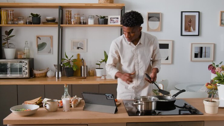 Uomo che cucina la colazione in una cucina moderna