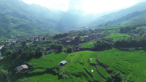 drone slowly zooms out revealing terraced paddies and distant mountains beneath dramatic sky light