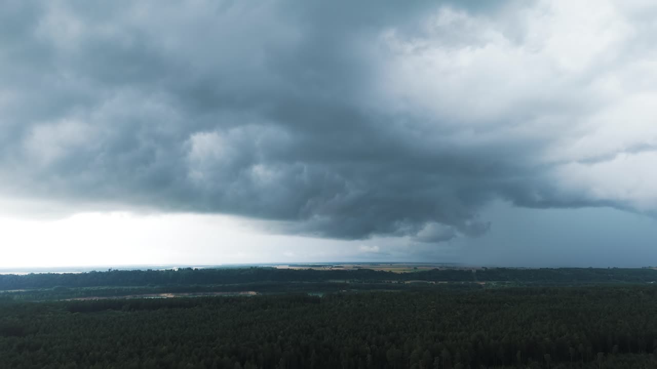 Epic dark clouds above countryside landscape of Lithuania, aerial view