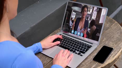 mujer caucásica haciendo una videollamada con una colega en una computadora portátil