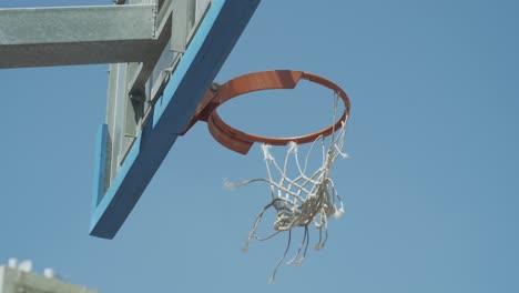Tilt-up-to-basketball-board-with-a-hoop-with-torn-net
