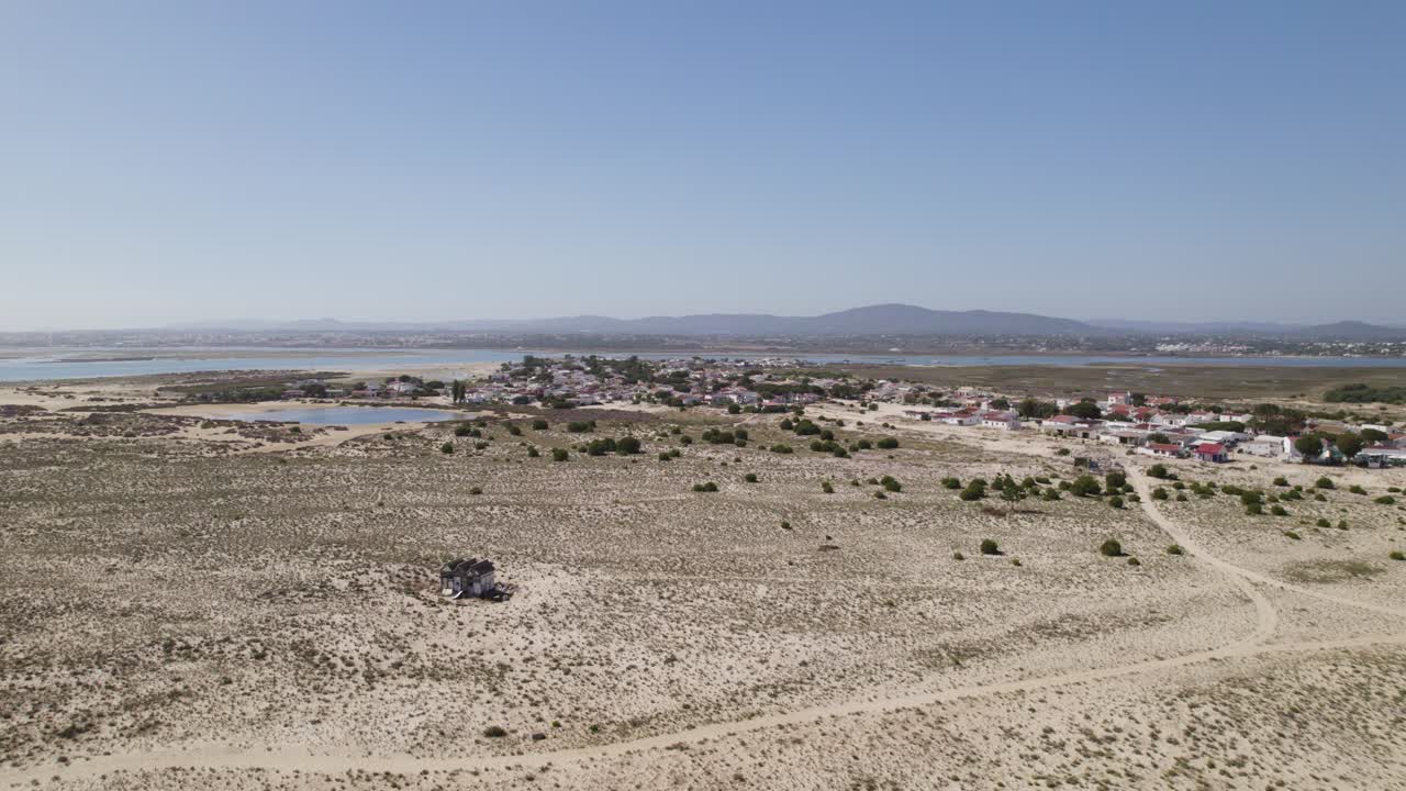 остров армона, португалия, демонстрирует небольшую прибрежную деревню, окруженную песчаной местностью, воздушный вид