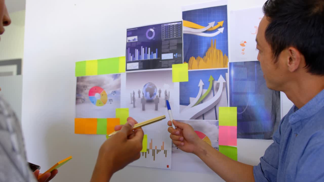 colegas de negocios multiétnicos discutiendo sobre gráficos y notas adhesivas en la oficina moderna 4k