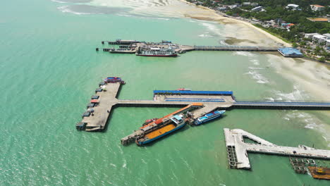 Aerial-circling-Nathon-pier-on-sunny-day,-Koh-samui,-Thailand